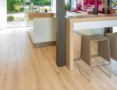 Die Küche ist mit hellem Holzlaminat ausgelegt. Eine Koch- und Essinsel mit drei Hockern lädt zum Verweilen ein.